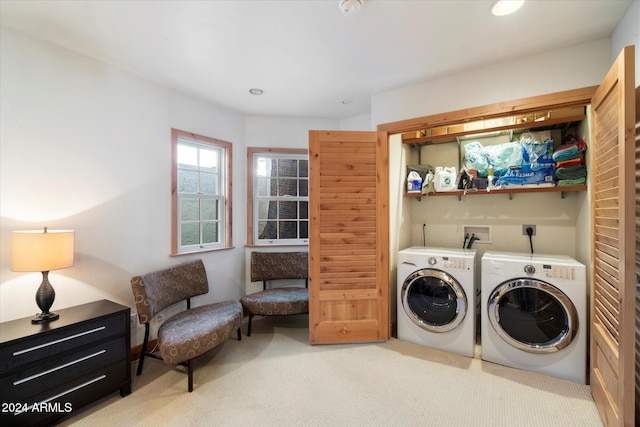 laundry area with independent washer and dryer and light colored carpet