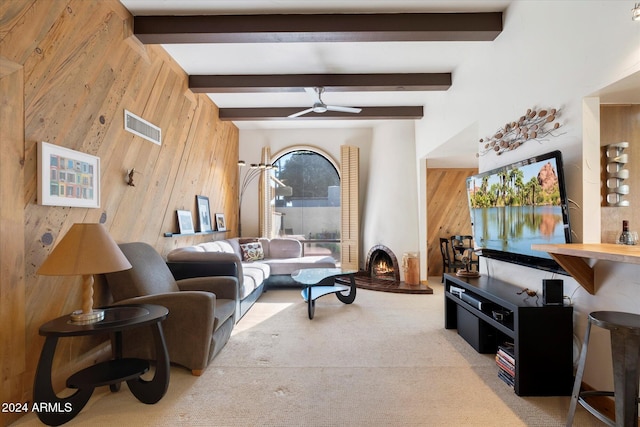 living room with beam ceiling, ceiling fan, and wooden walls