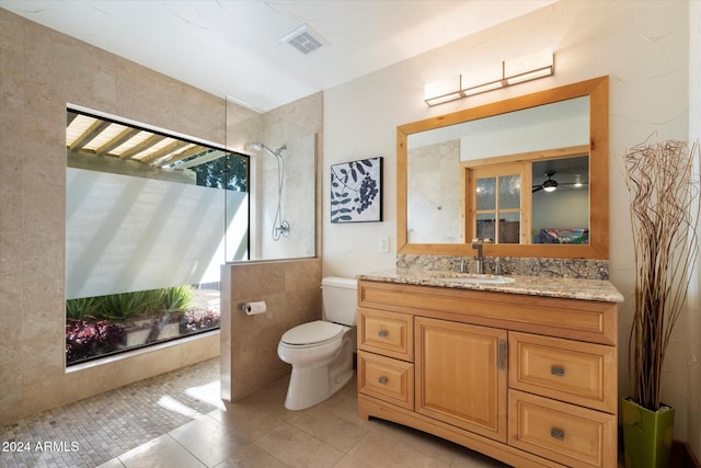 bathroom with tile patterned flooring, vanity, toilet, and ceiling fan