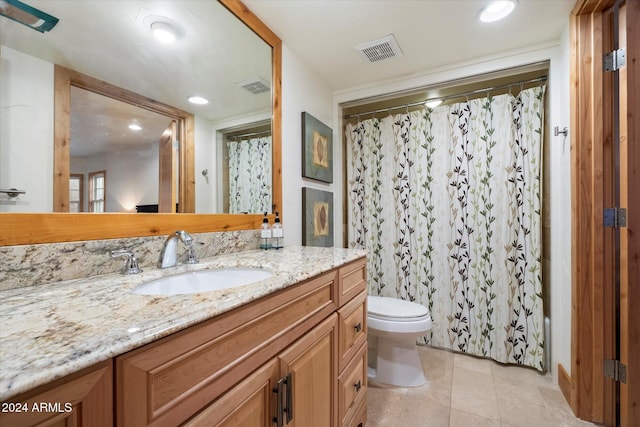 bathroom with tile patterned flooring, vanity, and toilet