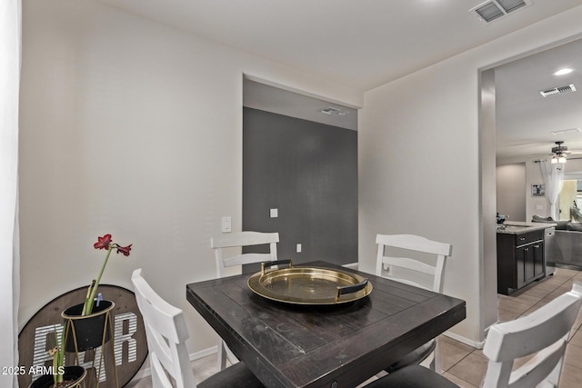 dining area with light tile patterned flooring, ceiling fan, and sink