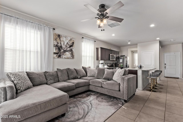 tiled living room featuring ceiling fan