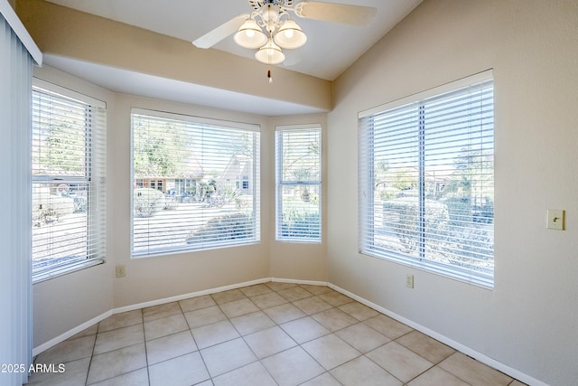 unfurnished room featuring ceiling fan, vaulted ceiling, and light tile patterned flooring