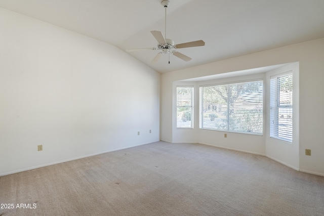 carpeted empty room featuring ceiling fan and lofted ceiling