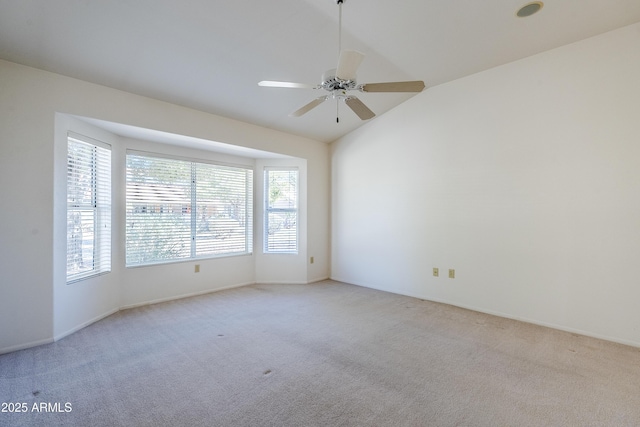 empty room featuring ceiling fan, light colored carpet, and lofted ceiling