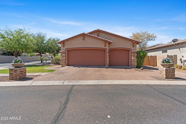3215 E Constance Way, Phoenix, AZ 85042 - mediterranean / spanish house featuring decorative driveway, stucco siding, and an attached garage