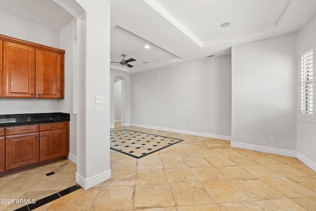 3215 E Constance Way, Phoenix, AZ 85042 - kitchen featuring arched walkways, a tray ceiling, inlaid floor details, a ceiling fan, and brown cabinetry