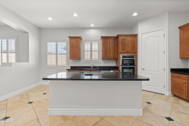 3215 E Constance Way, Phoenix, AZ 85042 - kitchen featuring stainless steel double oven, brown cabinets, a center island, recessed lighting, and light tile patterned flooring