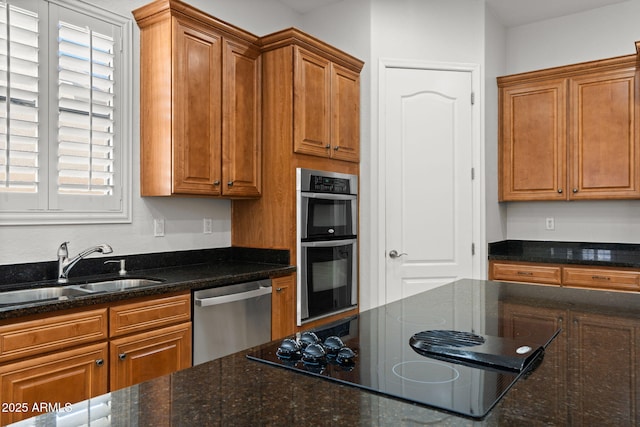 3215 E Constance Way, Phoenix, AZ 85042 - kitchen featuring appliances with stainless steel finishes, dark stone countertops, and brown cabinetry