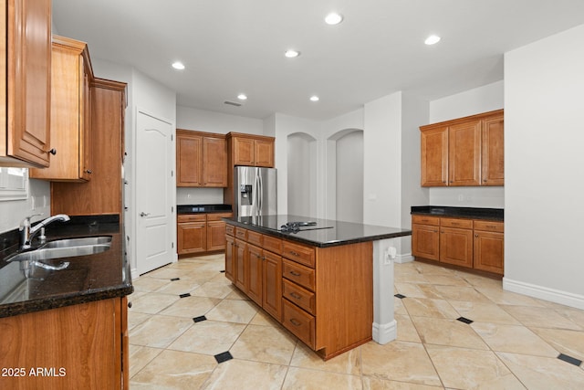 3215 E Constance Way, Phoenix, AZ 85042 - kitchen with stainless steel fridge, recessed lighting, a kitchen island, dark stone counters, and brown cabinets
