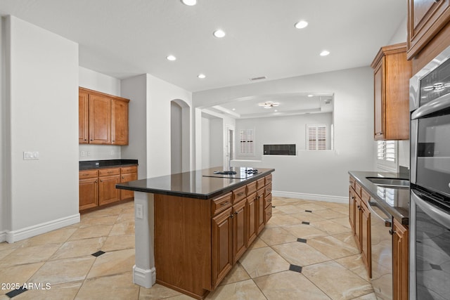 3215 E Constance Way, Phoenix, AZ 85042 - kitchen featuring appliances with stainless steel finishes, recessed lighting, brown cabinetry, light tile patterned floors, and a center island