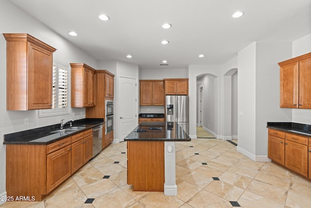 3215 E Constance Way, Phoenix, AZ 85042 - kitchen with appliances with stainless steel finishes, arched walkways, recessed lighting, a center island, and brown cabinetry