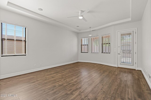 3215 E Constance Way, Phoenix, AZ 85042 - empty room featuring a tray ceiling, dark wood-type flooring, and a ceiling fan