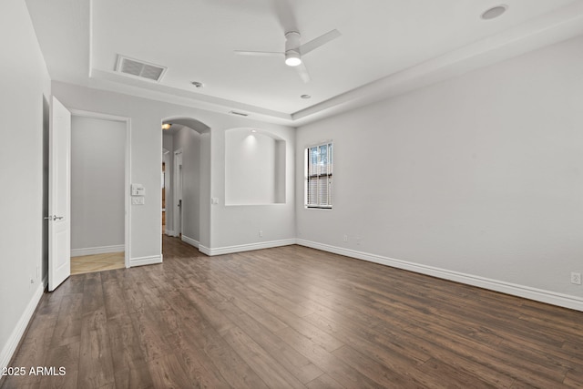 3215 E Constance Way, Phoenix, AZ 85042 - unfurnished room with a ceiling fan, arched walkways, dark wood-style floors, and a raised ceiling