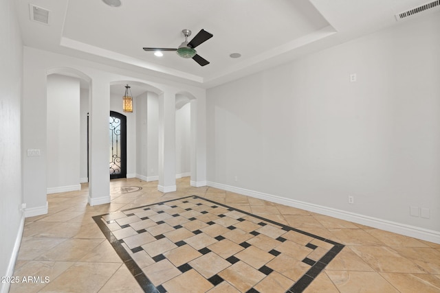 3215 E Constance Way, Phoenix, AZ 85042 - unfurnished room with a tray ceiling, arched walkways, a ceiling fan, and inlaid floor details