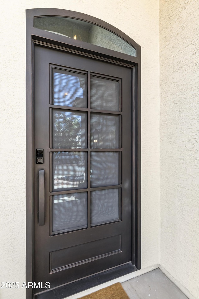 doorway to property featuring stucco siding