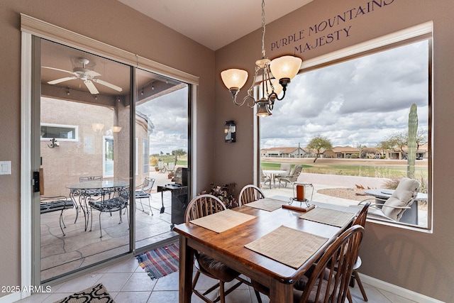 dining space featuring light tile patterned flooring and ceiling fan with notable chandelier