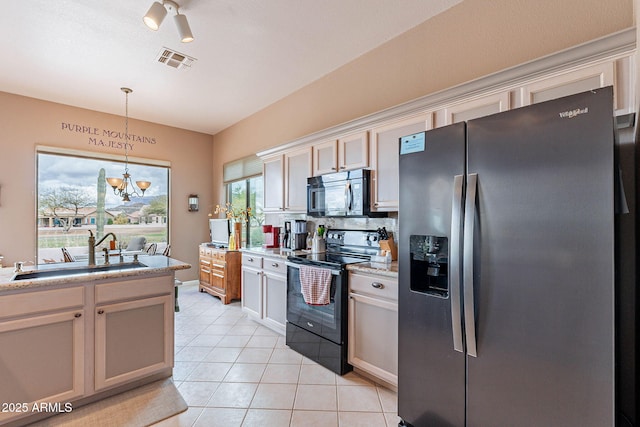 kitchen featuring visible vents, light tile patterned floors, a notable chandelier, black appliances, and a sink