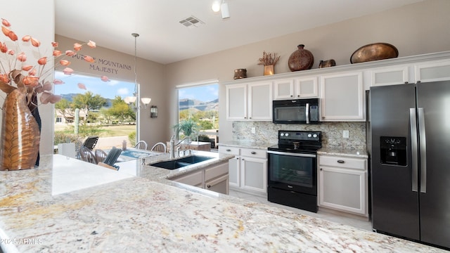 kitchen featuring visible vents, a sink, decorative backsplash, black appliances, and white cabinets