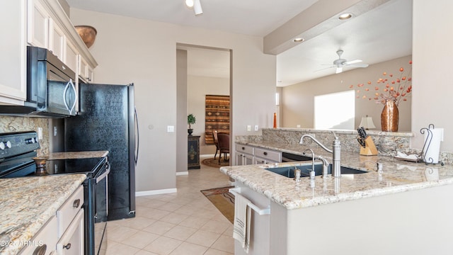 kitchen with black / electric stove, a ceiling fan, a sink, white cabinetry, and stainless steel microwave