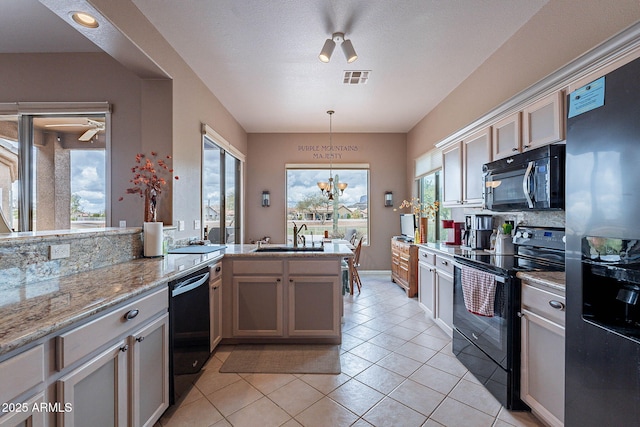 kitchen with visible vents, black appliances, a sink, light tile patterned floors, and a healthy amount of sunlight