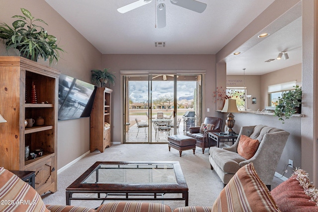 living room featuring visible vents, baseboards, ceiling fan, and carpet flooring