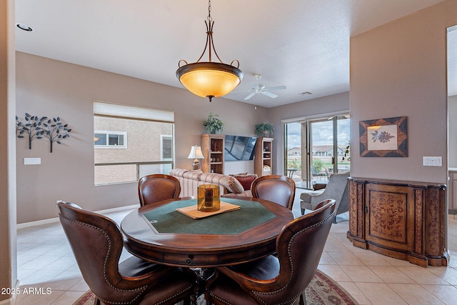 dining room with light tile patterned flooring, baseboards, and a ceiling fan