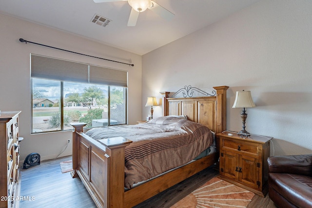 bedroom featuring visible vents, lofted ceiling, light wood finished floors, baseboards, and ceiling fan