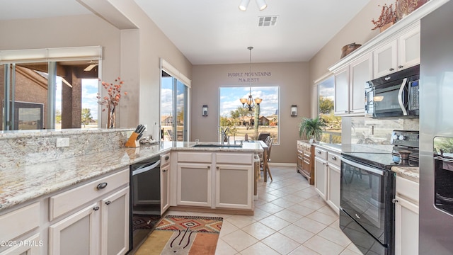 kitchen featuring visible vents, decorative light fixtures, light tile patterned floors, black appliances, and a sink