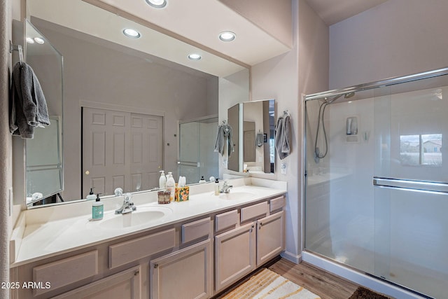 full bath with a sink, a stall shower, and double vanity