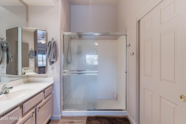 bathroom featuring vanity, a shower stall, and wood finished floors