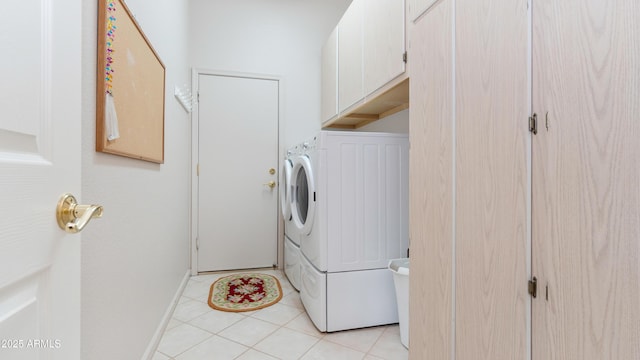 laundry room featuring cabinet space, baseboards, washer / clothes dryer, and light tile patterned flooring