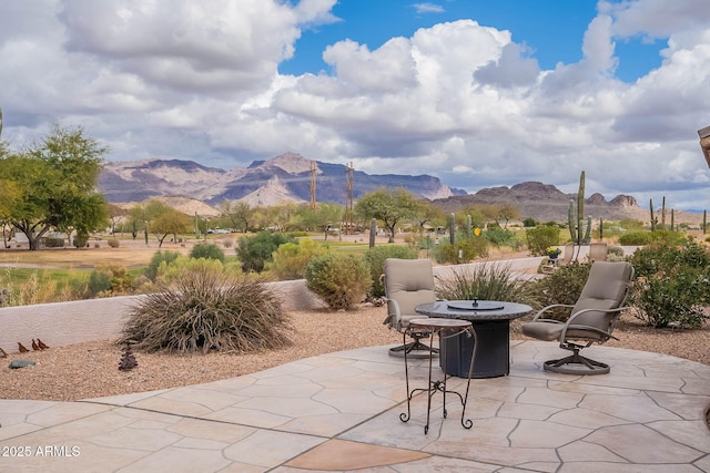 view of patio with a mountain view and a fire pit