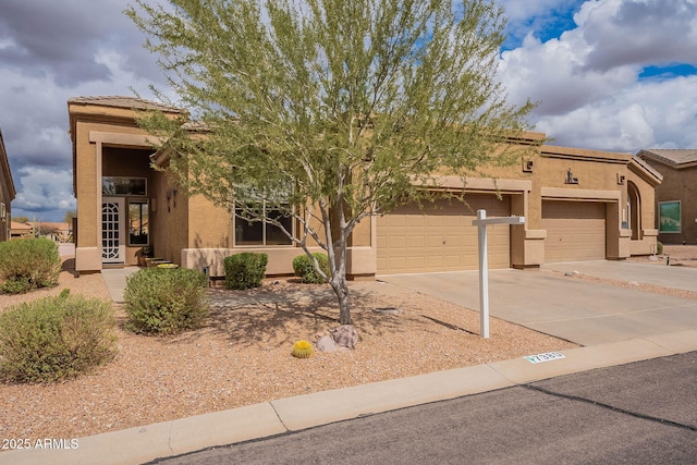 view of front of house with concrete driveway, an attached garage, and stucco siding