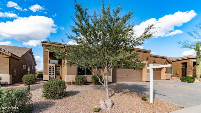 view of front facade featuring an attached garage, driveway, and stucco siding