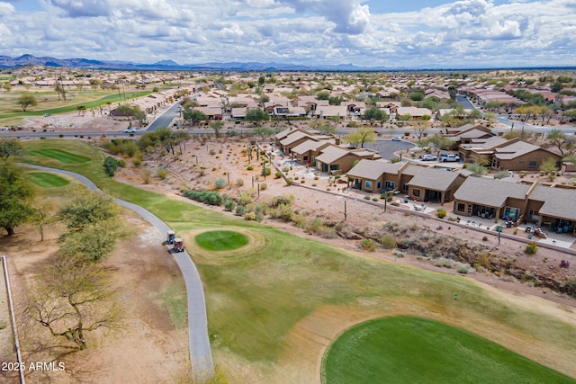 drone / aerial view with a mountain view, golf course view, and a residential view