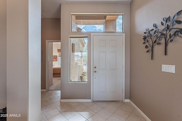 foyer entrance featuring baseboards and light tile patterned flooring