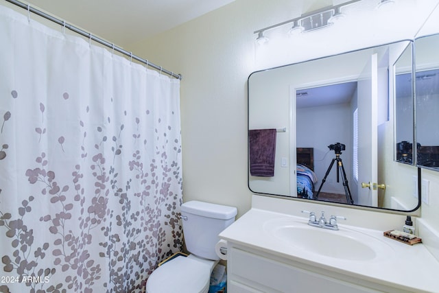 bathroom with vanity, toilet, and curtained shower