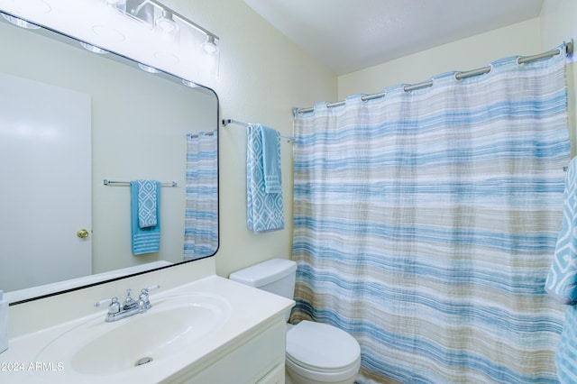 bathroom featuring vanity, a shower with shower curtain, and toilet