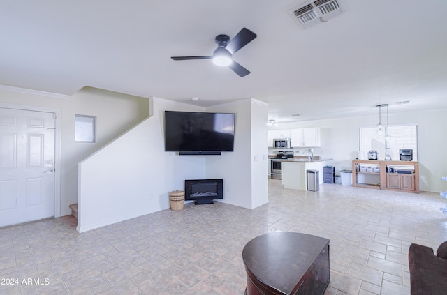 living room featuring ceiling fan and ornamental molding