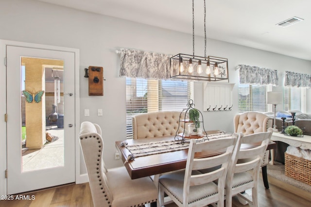 dining area with wood finished floors and visible vents