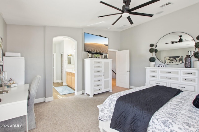 carpeted bedroom with arched walkways, visible vents, baseboards, ensuite bath, and washer / dryer