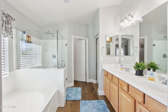 full bath featuring double vanity, a garden tub, a shower stall, and a sink