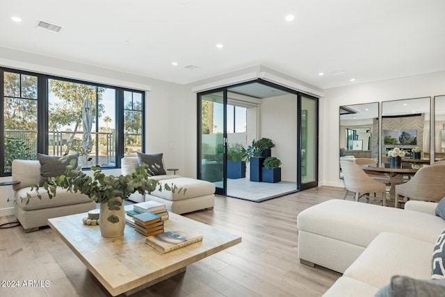 living room with a wealth of natural light and light hardwood / wood-style flooring