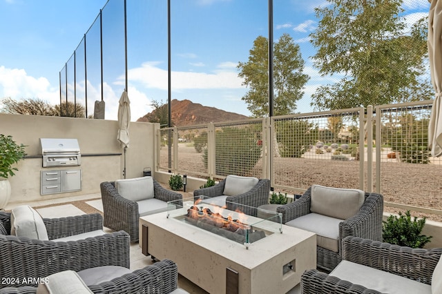 view of patio with a grill, a mountain view, and an outdoor fire pit