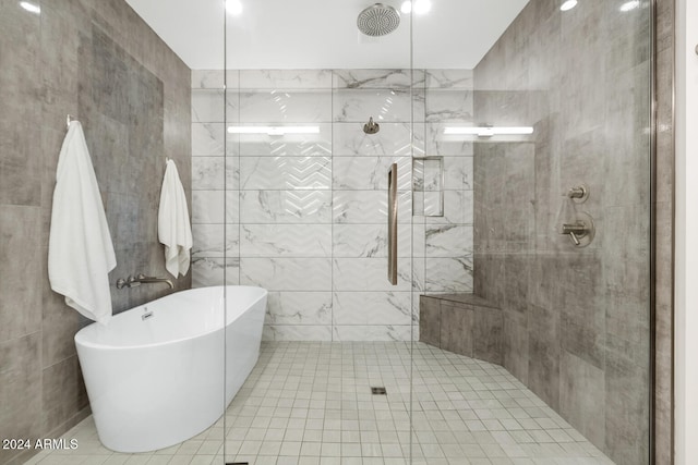 bathroom with tile patterned flooring, independent shower and bath, and tile walls