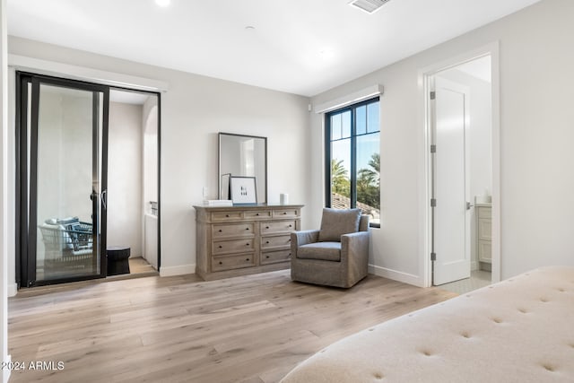 bedroom featuring light wood-type flooring and connected bathroom