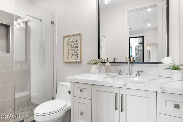 bathroom featuring vanity, a shower with shower door, and toilet