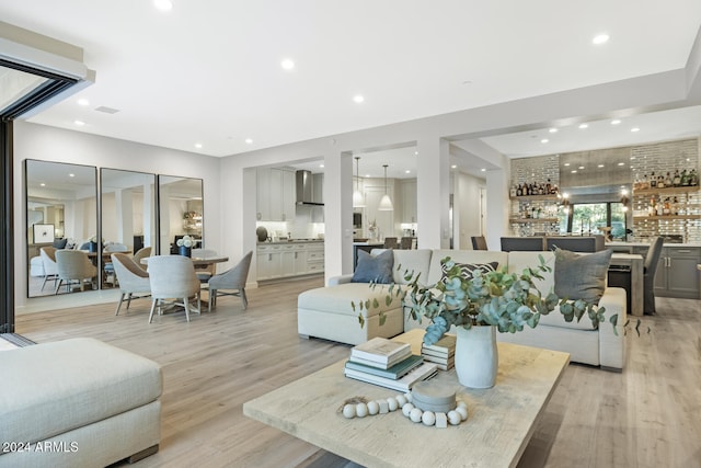 living room with light wood-type flooring and bar area