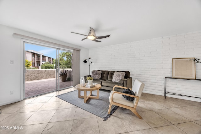 living room featuring brick wall, ceiling fan, and light tile patterned floors